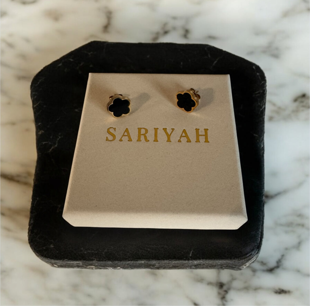 Gold earrings on a 'SARIYAH' branded card against a marble background Waterproof Jewellery Piece